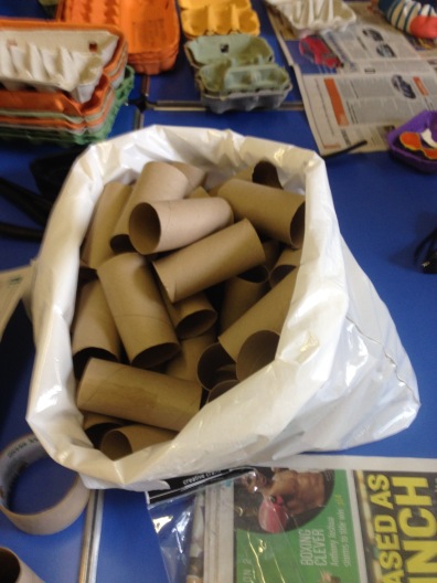 A huge bag of toilet roll tubes sits on a table, a pile of egg boxes is in the background. 